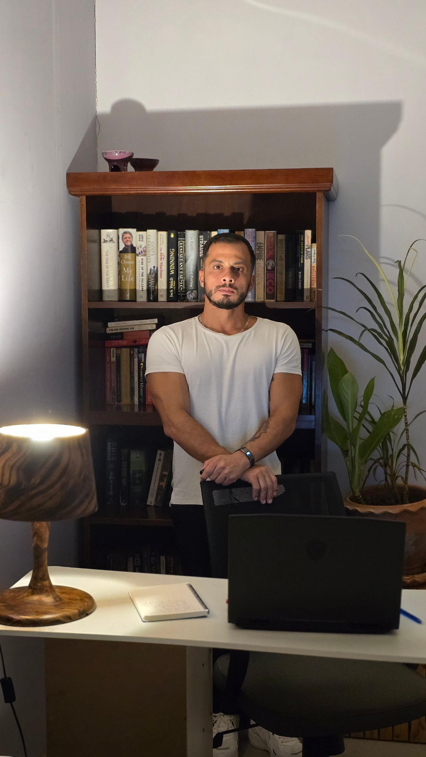 Mohamad El Ghali standing in front of a bookshelf in his office